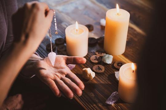 Pendulum scrying with runes and crystals on the table